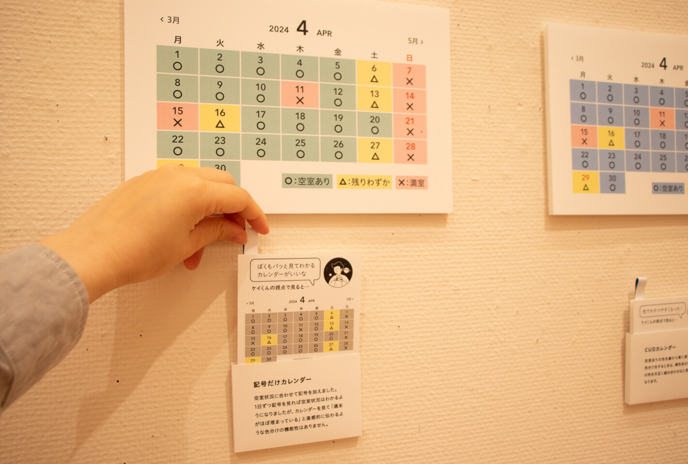 写真:色分けをしたカレンダーの下にキャプションがついています。「ケイくんの視点で見ると…」というカードを引き出すと、カレンダーに色覚シミュレーションをかけた結果が見える仕掛け。