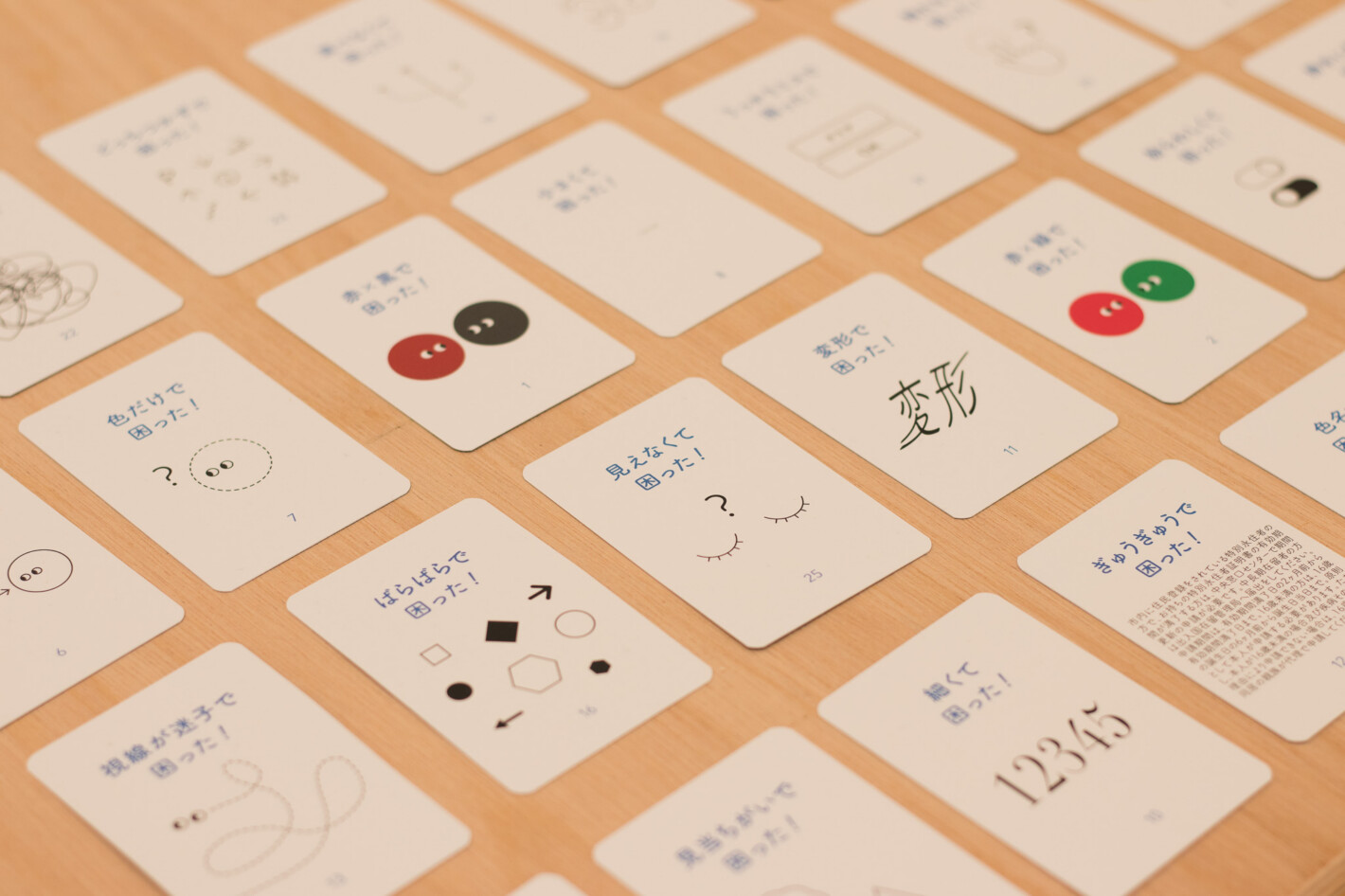 写真:「見えなくて困った!」「ばらばらで困った!」など困りごとのタイトルとイラストが書かれたカードが机の上に並んでいる。