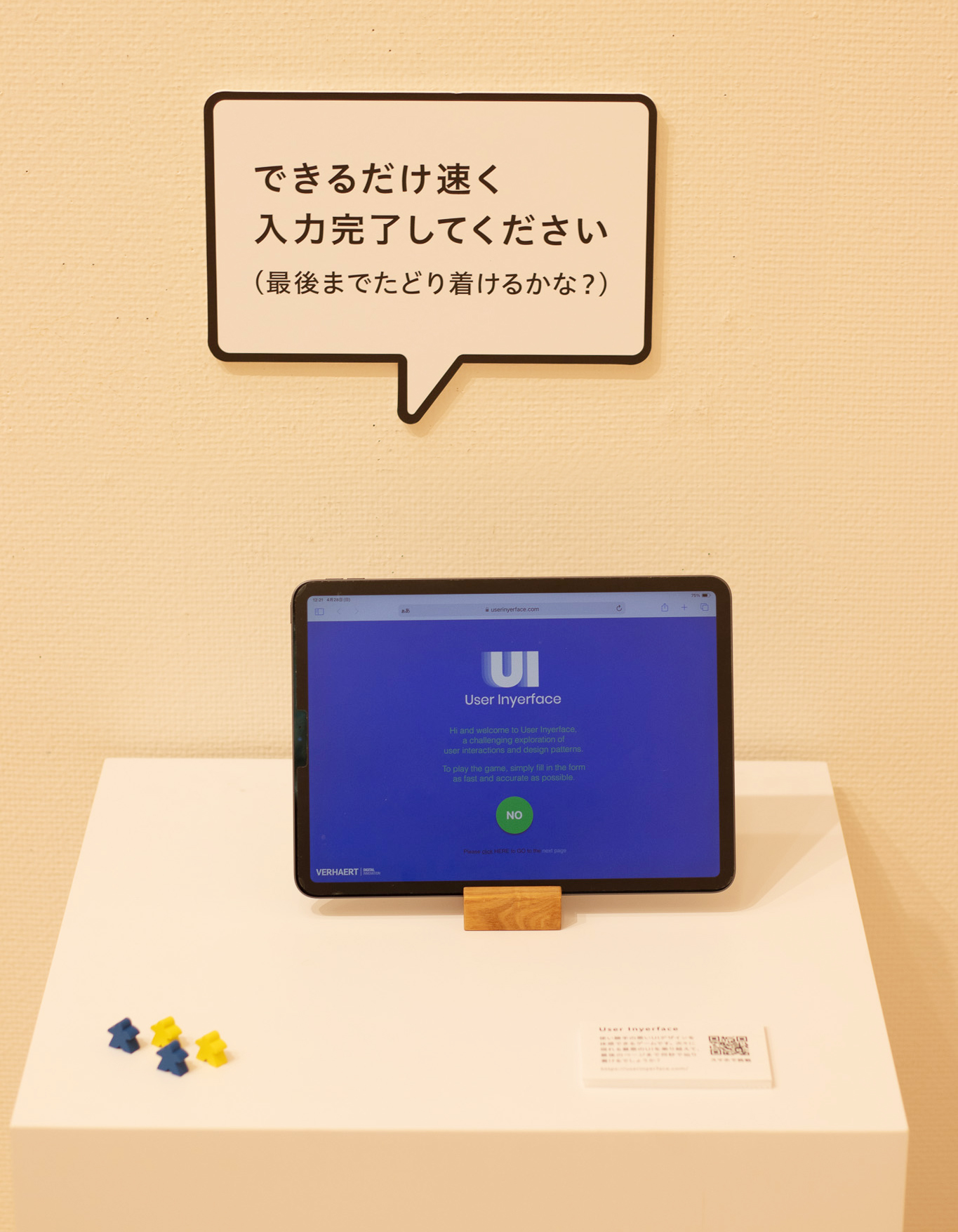 写真:ウェブサイトの入り口ページを表示したタブレットの上に「できるだけ速く入力完了してください(最後までたどり着けるかな?)」という吹き出し型のパネルがついています。