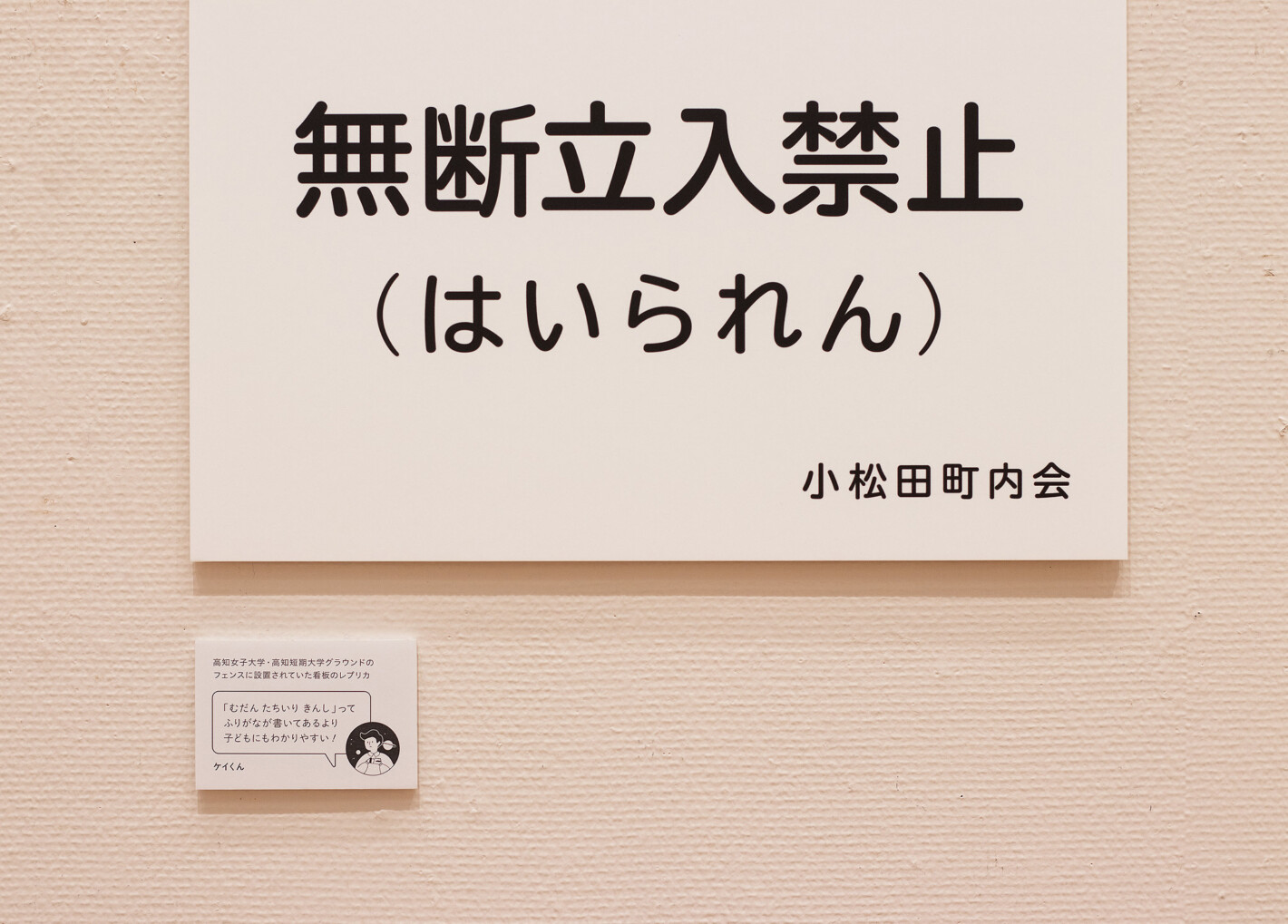 写真:「無断立入禁止(はいられん)」というパネルとそのキャプション。高知女子大学・高知短期大学グラウンドのフェンスに設置されていた看板のレプリカ。ケイくんのセリフ「むだんたちいりきんしってふりがなが書いてあるより子どもにもわかりやすい!」