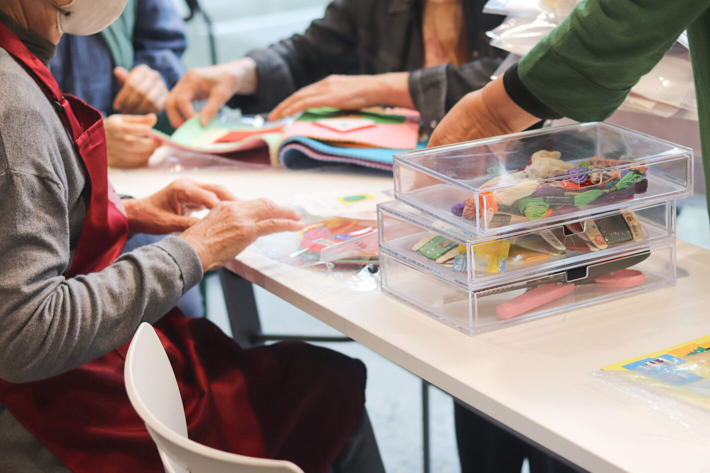 写真:机の上に布絵本やその素材を広げるみなさんの手